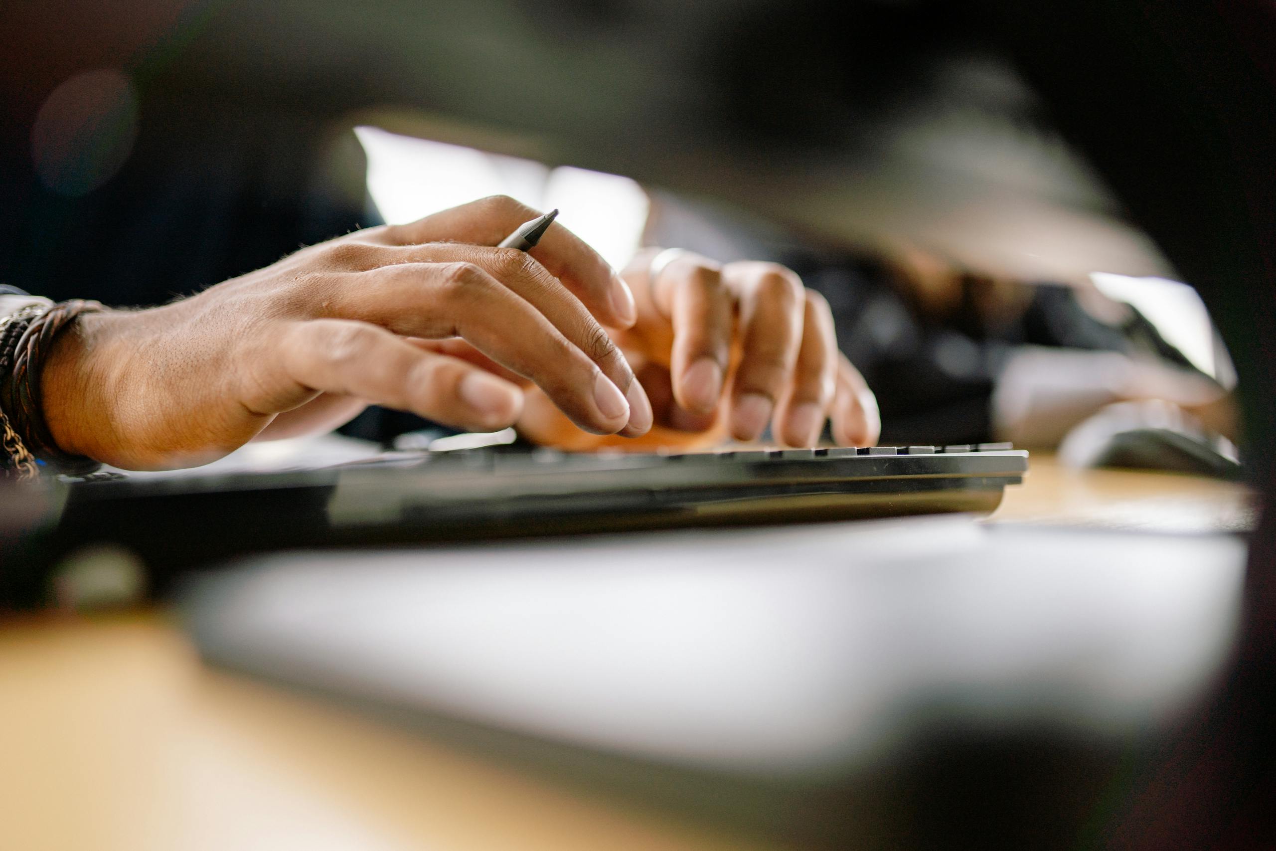 A detailed view of a person typing on a keyboard, emphasizing productivity and office work.